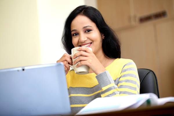 Woman drinking coffee and reading a book